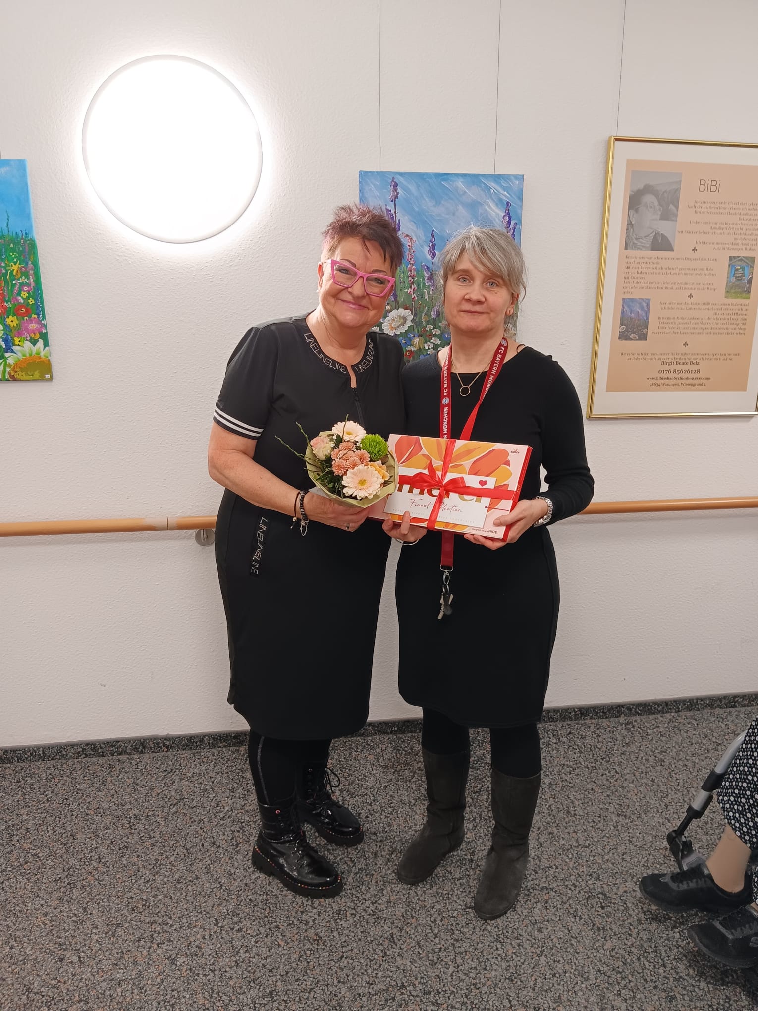 die Künstlerin bekommt Blumen und Schokolade überreicht